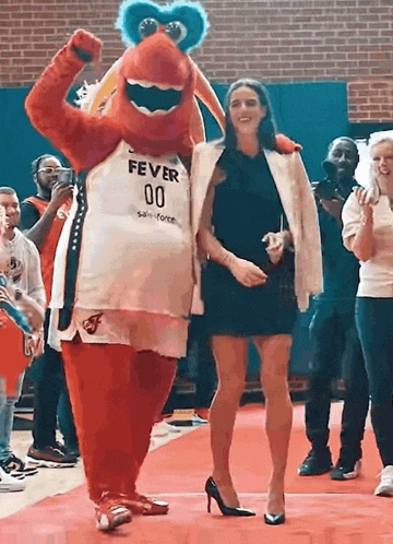 a woman is standing next to a mascot wearing a fever 00 jersey