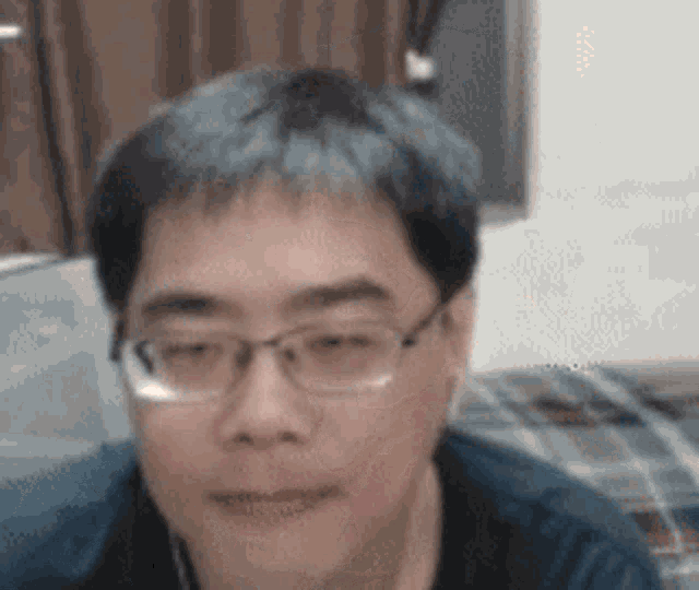 a close up of a man 's face with glasses on