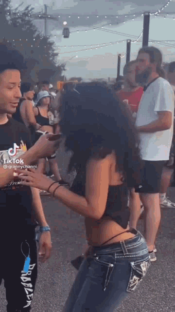 a woman in a crop top is dancing in a crowd of people .
