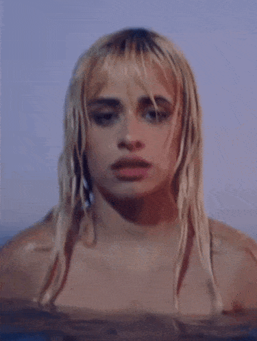 a woman with blonde hair is swimming in a body of water