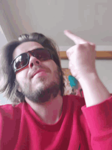 a man with a beard wearing sunglasses and a red shirt