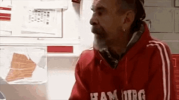 a man wearing a red shirt that says hamburg