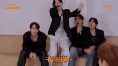 a group of young men are dancing in front of a sign that says we ver.