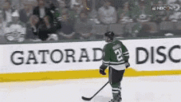 a hockey player stands on the ice in front of a gatorade advertisement