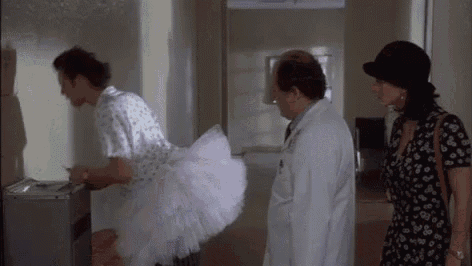a woman in a tutu is standing next to a doctor and a woman in a dress .