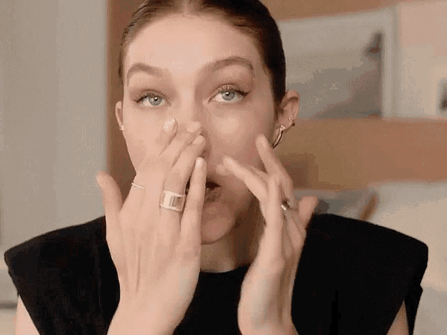 a woman with a ring on her finger is covering her mouth