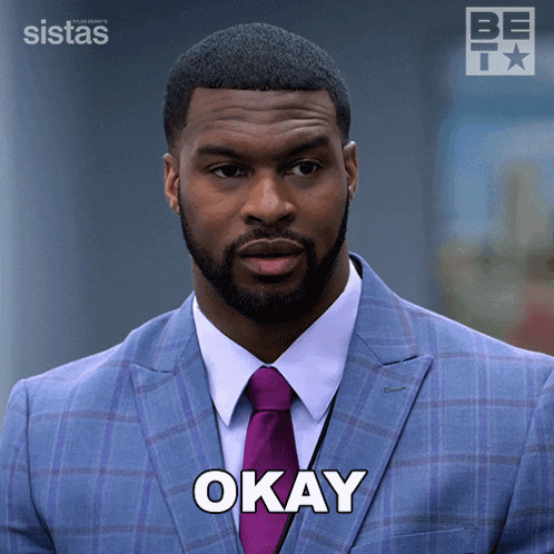a man in a suit and tie with the word okay on his chest