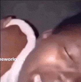 a close up of a person holding a baby 's head .