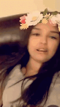 a woman with a flower crown on her head is smiling