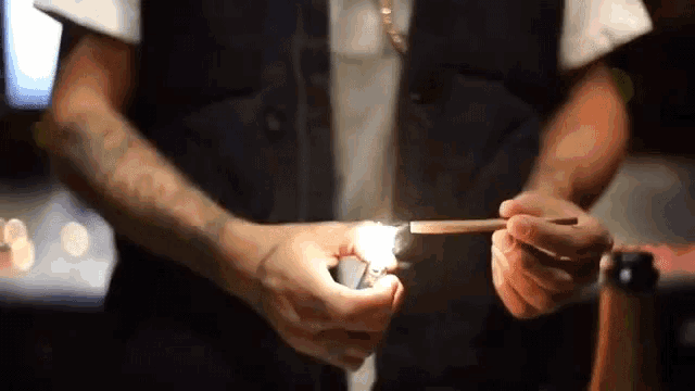 a man lighting a cigarette with a lighter