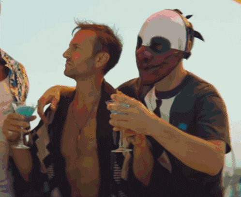 a man wearing a mask holds a martini glass