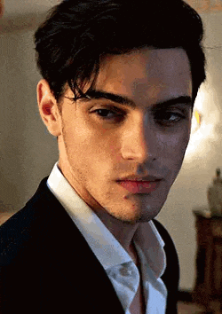 a close up of a young man wearing a suit and white shirt .