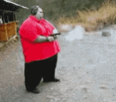 a fat man in a red shirt holds a gun