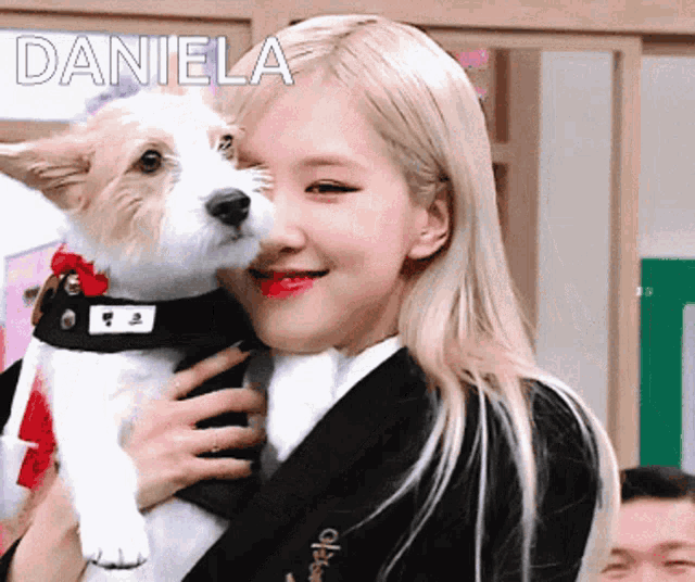 a woman is holding a small brown and white dog with the name daniela written above her
