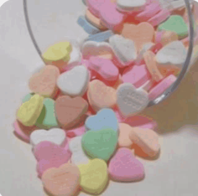candy hearts are poured out of a glass jar