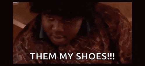 a man is standing in front of a crowd of children and says `` them my shoes '' .
