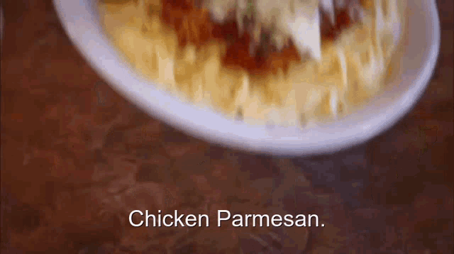 chicken parmesan is being added to a plate of spaghetti