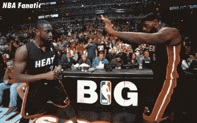 two basketball players are giving each other a high five in front of a banner that says big