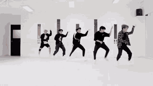 a group of young men are dancing together in a room .