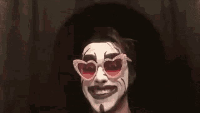 a man with white face paint and heart shaped sunglasses
