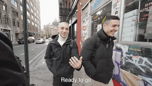 two men walking down a street with the words " ready to go " on the bottom right