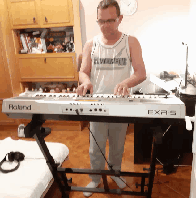 a man playing a roland keyboard in a room