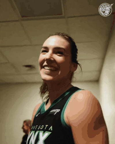 a woman in a minnesota lynx jersey is smiling