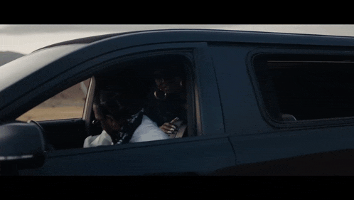 a person sitting in a car looking out the window at something