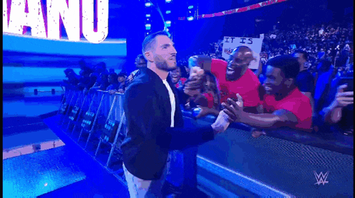 a man stands in front of a crowd with a sign that says it is