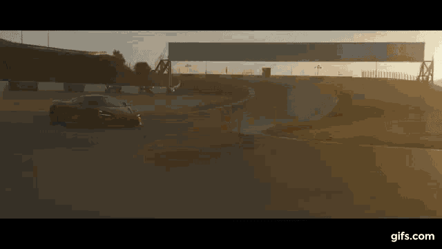a red sports car is driving down a race track .