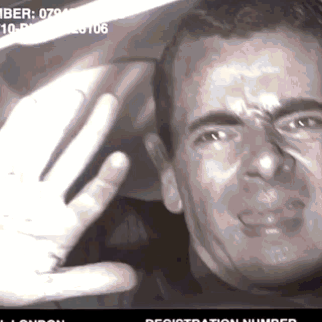 a man 's face is shown in a black and white photo with the number 079 on it