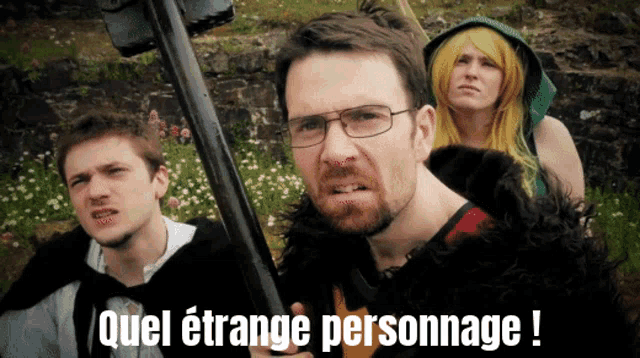 a man with glasses holds a gun in front of a group of people with the words quel etrange personnage written on the screen