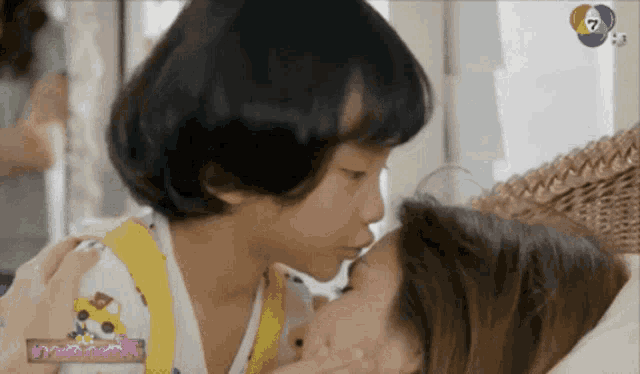 a girl kissing another girl with the number 7 on the bottom right corner