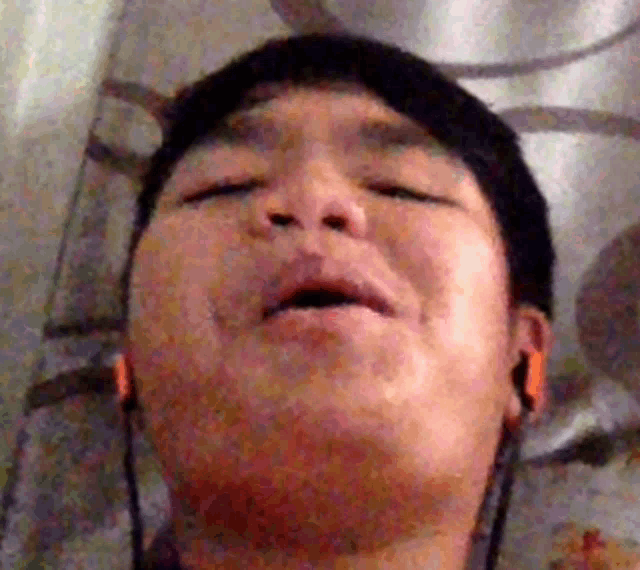 a man wearing ear buds is making a funny face with his mouth open