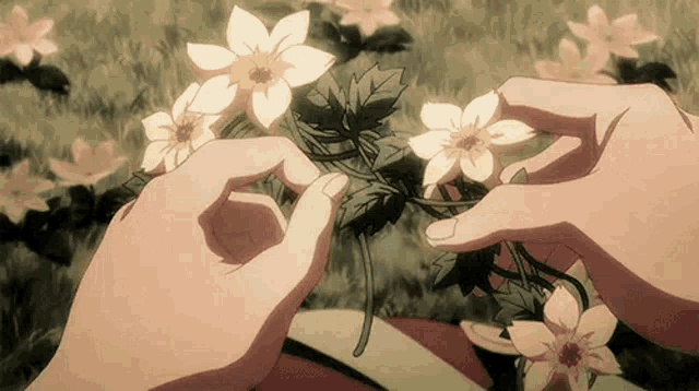 a person is holding a bunch of flowers in their hands in a garden .