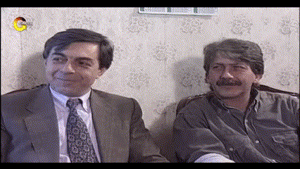 two men in suits and ties are sitting next to each other on a couch