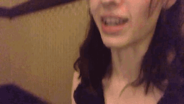 a close up of a woman 's face with her mouth open and a blurred background .
