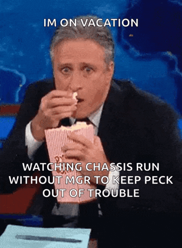 a man in a suit and tie is eating popcorn and says im on vacation