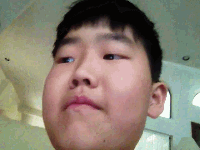 a close up of a young boy 's face with his mouth open