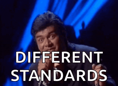 a man is singing into a microphone and the words different standards are behind him