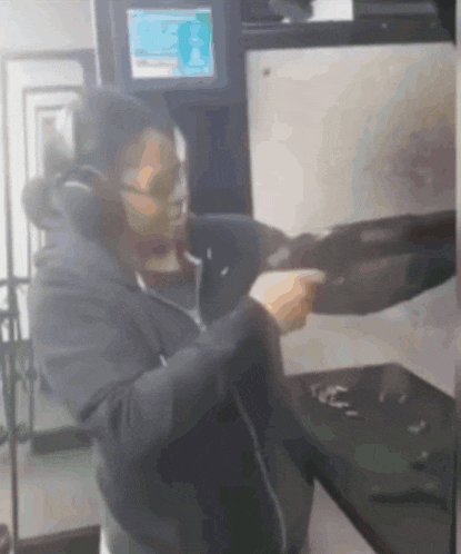a blurred image of a man holding a gun with a screen behind him that says ' a '