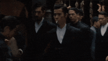 a man with a beard is standing in a crowd of men