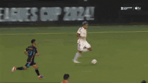 a soccer goalie dives to catch a ball in front of an at & t advertisement