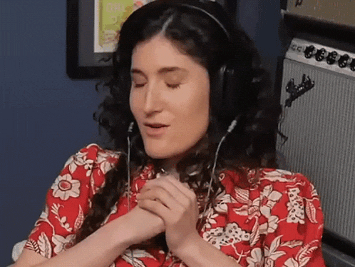a woman wearing headphones is sitting in front of an amplifier