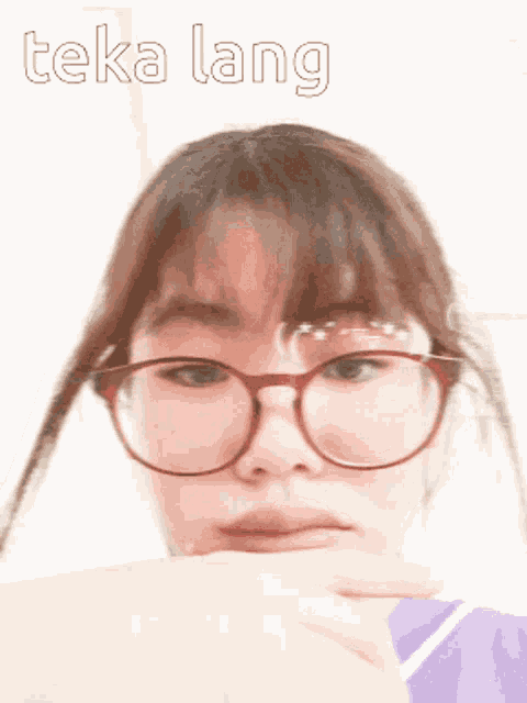 a girl wearing glasses and a purple shirt has the word teka lang written above her