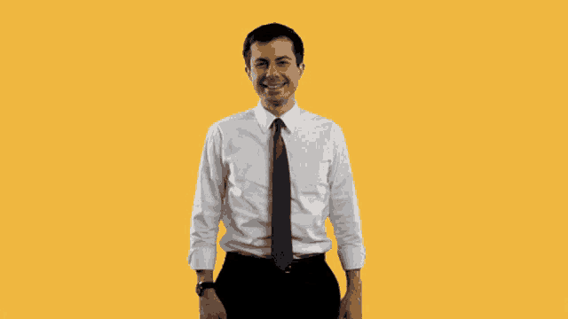 a man in a white shirt and tie is standing in front of a yes sign