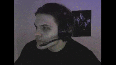 a man in a black shirt is wearing a headset and making a funny face .