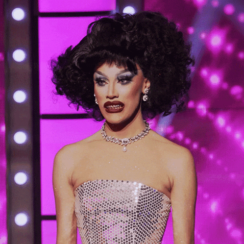 a drag queen wearing a sequined top and a necklace