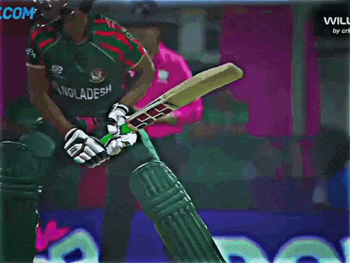 a cricket player is swinging a bat in front of a banner that says com