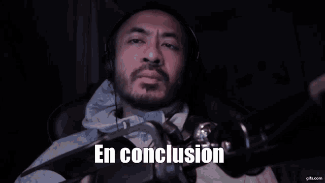 a man wearing headphones is sitting in front of a microphone and says en conclusion